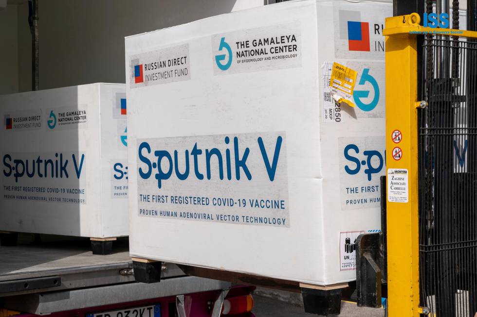 Bildet er av gaffeltruck som laster opp en kasse med vaksinen Sputnik V. Det blir løftet inn i en lastebil.