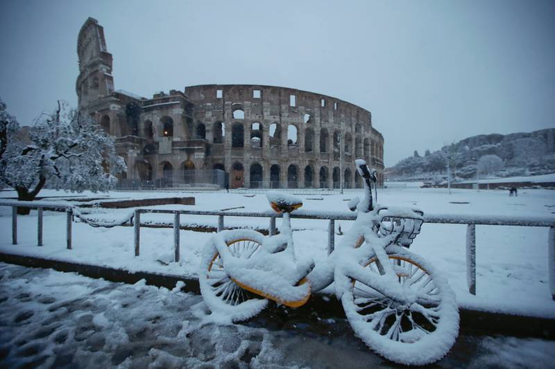 Bildet viser snø ved Colosseum i Roma i Italia.