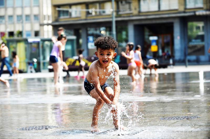 Bildet viser en gutt som leker i en vannfontene i Brussel i Belgia.
