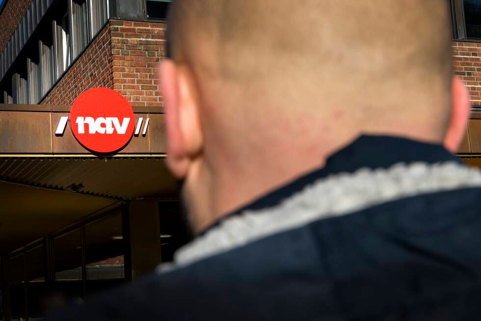 Bildet er av en mann som ser på en murbygning med Nav-logoen. Han har kort hår, og bildet er tatt bakfra. Foto: Gorm Kallestad / NTB