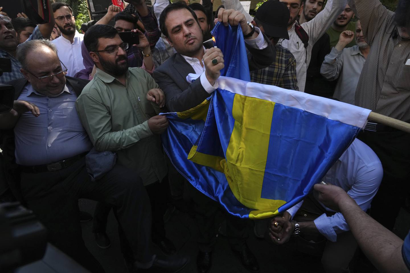 Bildet viser iranere som brenner svensk flagg.
