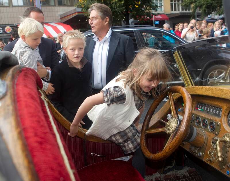 Bildet er av prinsesse Ingrid Alexandra som klatrer raskt inn i en bil. Bak står brødrene og kronprins Haakon. Der står også Remo Caprino. Han er sønn av Ivo Caprino som laget filmen Flåklypa Grand Prix, hvor bilen var med. Foto: Terje Bendiksby  / NTB