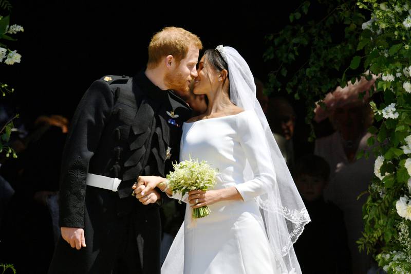 Bildet viser prins Harry og Meghan Markle som kysser på trappa til  St George's Chapel i Windsor.