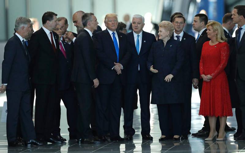 Bildet viser Donald Trump som retter på jakken sin etter å ha kommet seg fremst i bildet. Han står blant en gruppe statsledere.