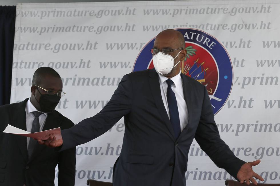 Bildet er av Haitis statsminister Ariel Henry. Han slår ut med armene. Han har på seg dress og munnbind. Arkivfoto: Joseph Odelyn / AP / NTB