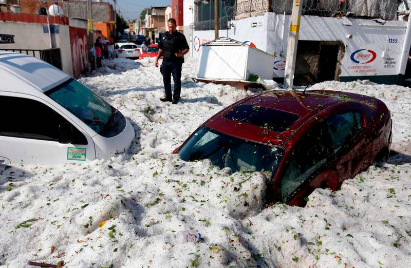 Bildet viser to biler som er dekket av snø og is opp til taket.