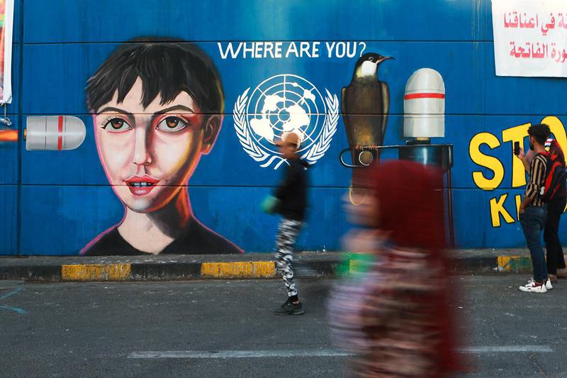 Bildet viser et veggmaleri i Bagdad i Irak. Den viser en kule som er på vei til å treffe en person. Ved siden av er logoen til FN og teksten «Hvor er FN?».