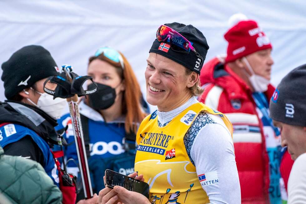 Bildet er av Johannes Høsflot Klæbo i skiutstyr. Han smiler bredt etter å ha vunnet Tour de Ski. Det står mye folk i bakgrunnen, både med og uten munnbind. Foto: Terje Pedersen / NTB