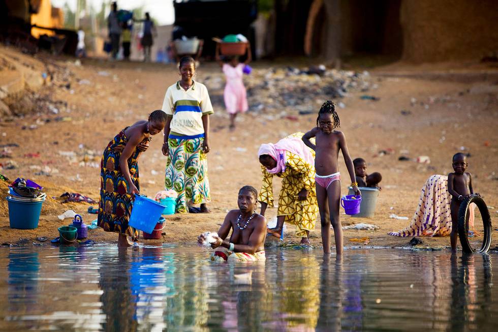 Bildet viser kvinner fra Mali som vasker klær og seg selv. Det skjer i Niger-elven ved Segou. 