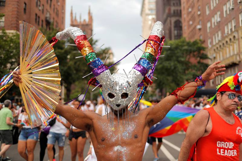 Bildet viser en mann i sølvmaske med horn i regnbuens farger. Mannen har også sølvglitter på brystet.
