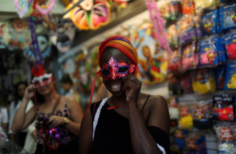 Bildet viser en kvinne som prøver en maske i en butikk.