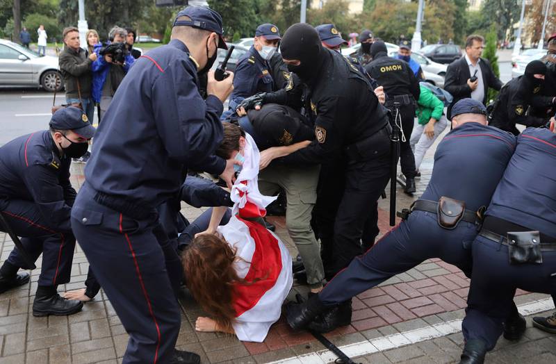 Bildet viser politi som pågriper en demonstrant i Hviterussland.