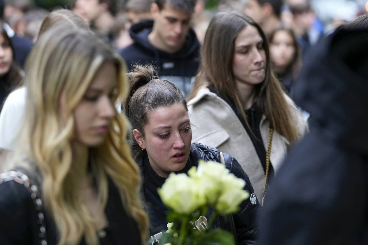 Flere samlet seg utenfor skolen torsdag for å legge ned blomster og minnes de som ble drept i skoleskytingen. Foto: Darko Vojinovic / AP / NTB