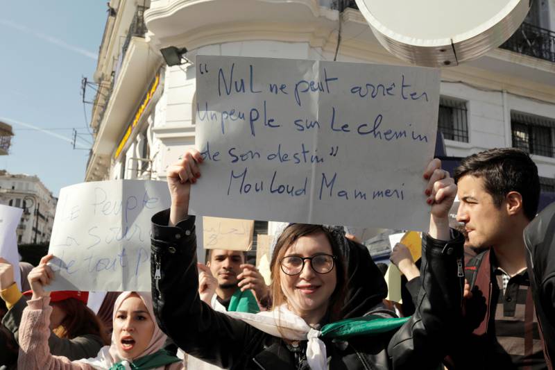Bildet viser en kvinne med en plakat som protesterer i Algerie.
