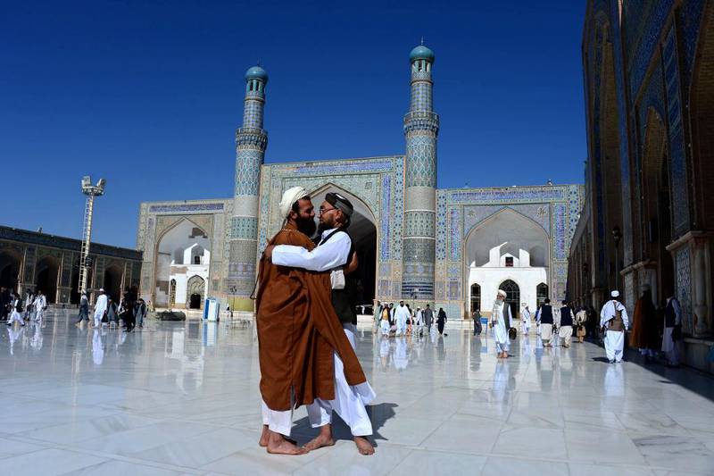 Bildet viser to afghanske mannlige muslimer som klemmer hverandre.