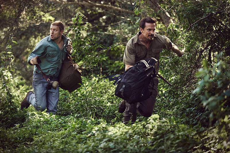 Bildet viser Tobias Santelmann og Aksel Hennie i filmen mens de løper igjennom en jungel. 