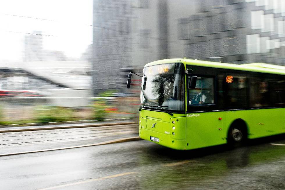 Bildet viser en grønn buss i fart. 