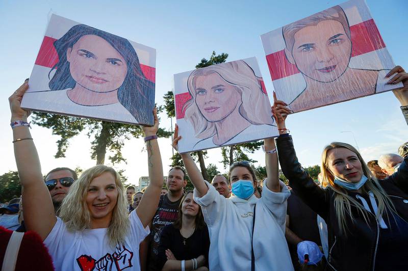 People hold portraits of Svetlana Tikhanovskaya, candidate for the presidential elections, left, wife of non-registered candidate Valery Tsepkalo, Veronika Tsepkalo, centre, Maria Kolesnikova, a representative of Viktor Babariko, right, during a meeting in Borisov, Belarus, Thursday, July 23, 2020. The longtime leader of Belarus President Alexander Lukashenko warned Thursday that Western media could be expelled from the country over what he described as their "tendentious" coverage of the presidential election next month in which he is seeking a sixth term. The presidential election in Belarus is scheduled for August 9, 2020. (AP Photo/Sergei Grits)