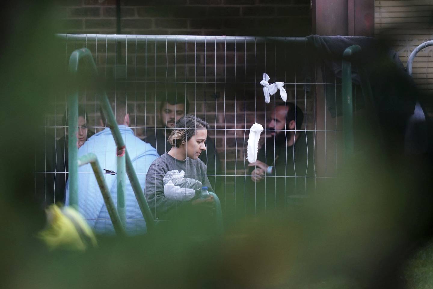 Det som antas å være migranter på innsiden av et lukket asylmottak i Thanet i England. Foto: Gareth Fuller / PA via AP / NTB