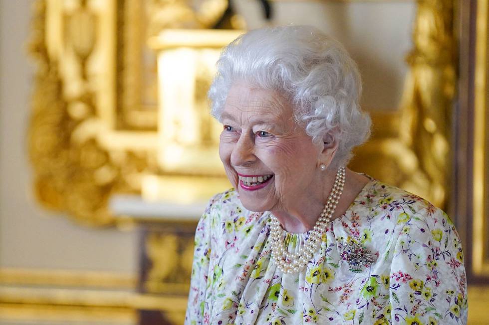 Bildet er av dronning Elizabeth. I bakgrunnen er det en kremhvit vegg med gullfargede detaljer. Foto: Steve Parsons / AFP / NTB