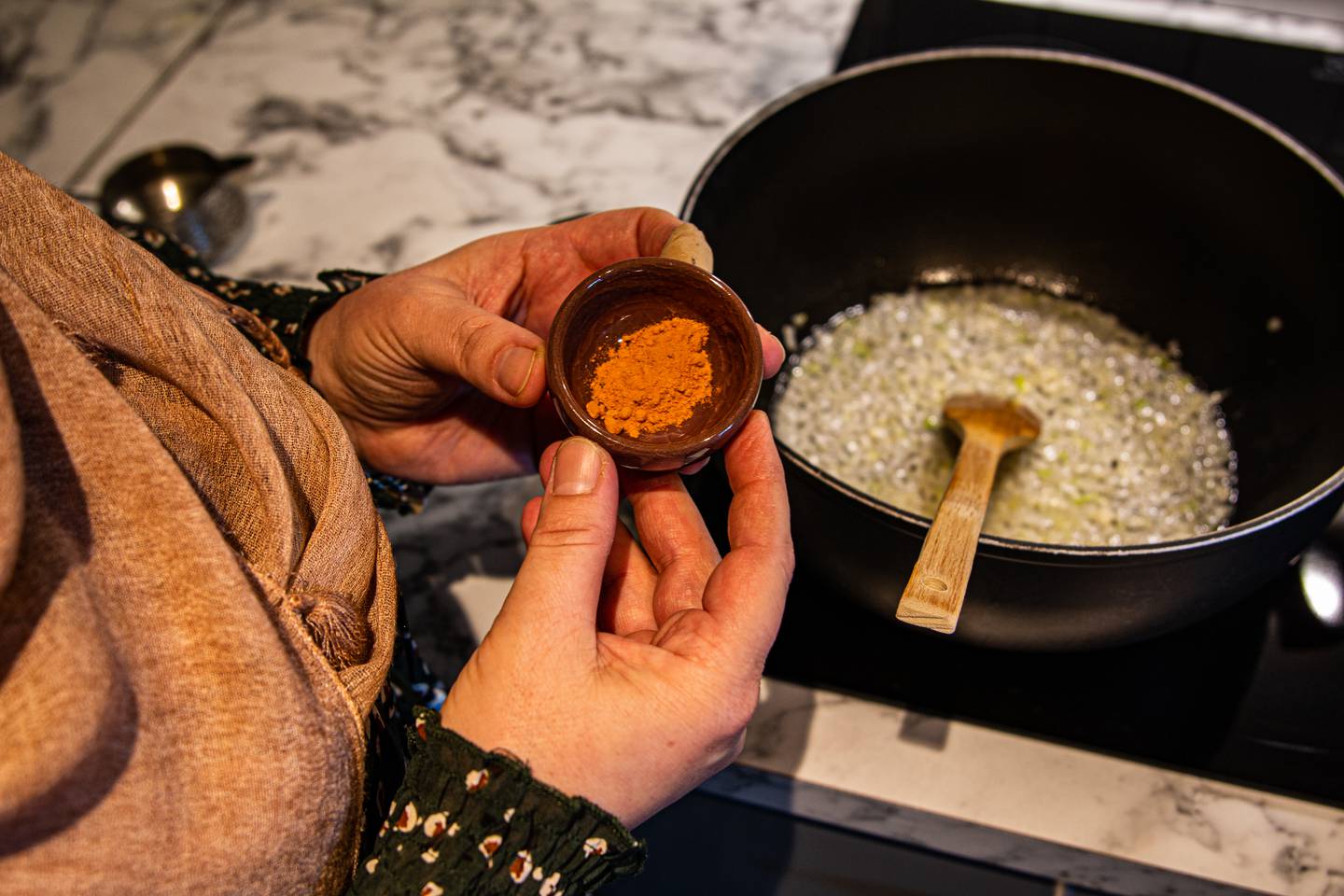 Golalah viser fram krydderet gurkemeie, som hun har i en liten brun skål.