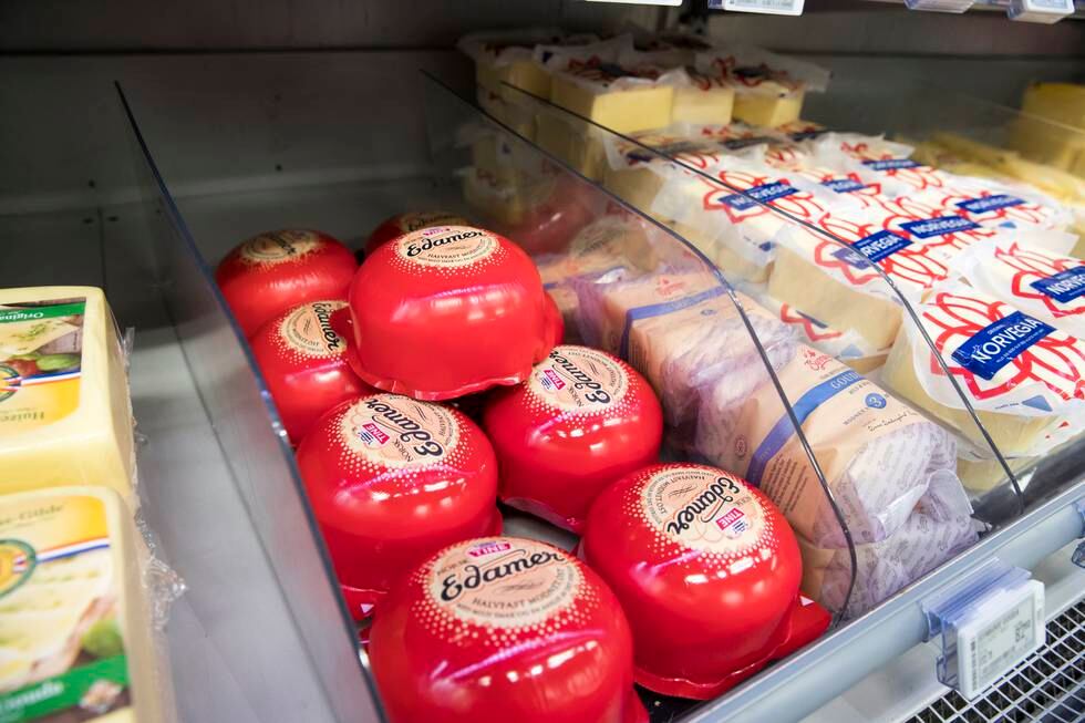 Bildet viser flere typer ost i en matbutikk.
