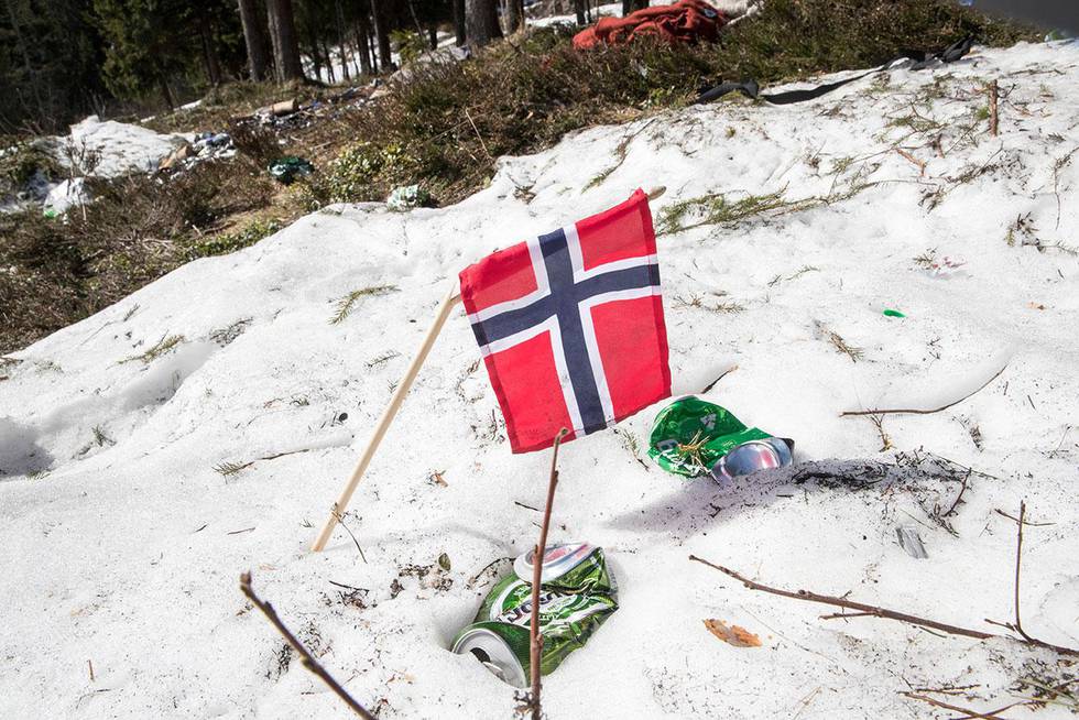 Bildet viser et knekt Norges-flagg og ølbokser strødd på bakken i Holmenkollen. I fjor ble det fyll og spetakkel under femmila i Holmenkollen. Arrangørene håper å unngå at det samme skjer i år.