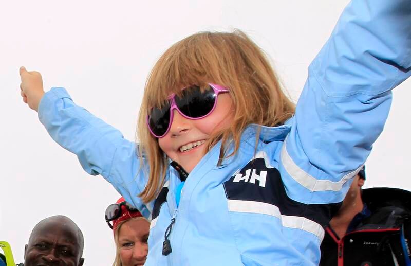 Bildet er av en sju år gammel prinsesse Ingrid Alexandra som jubler med armene i været. Hun har på solbriller og lyseblå jakke. Bildet er fra toppen av fjellet Galdhøpiggen. 
Foto: Cornelius Poppe / NTB