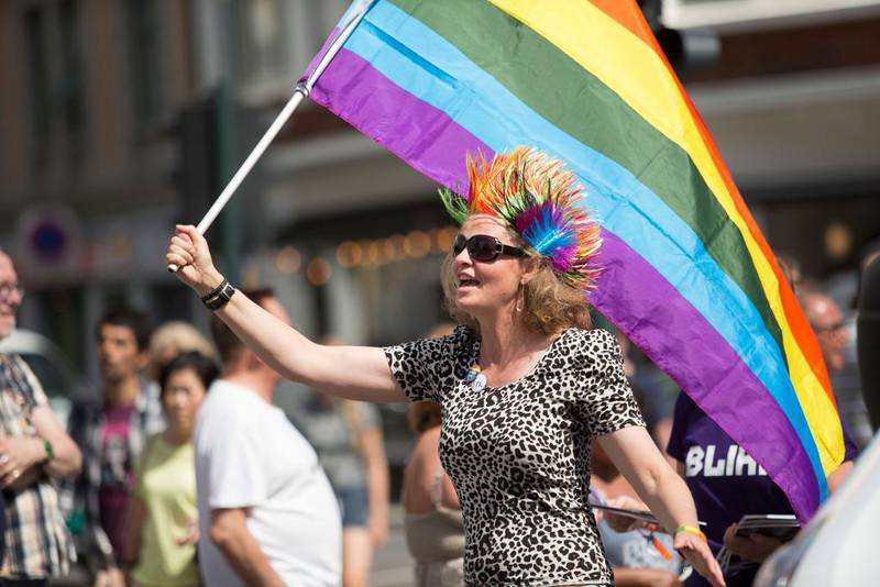 Bildet viser en kvinne med et flagg med farger av regnbuen.