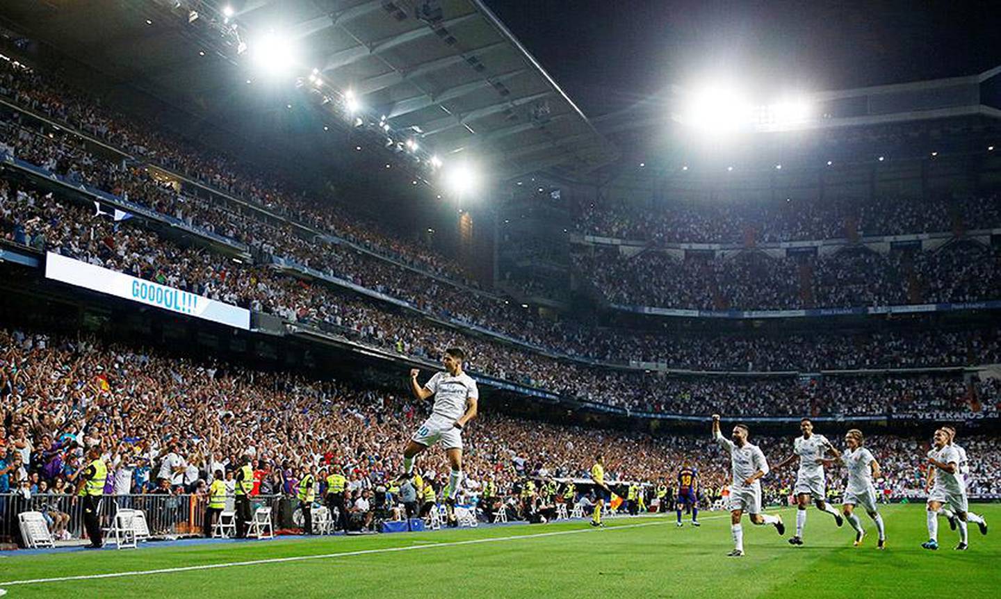 Bildet viser Marco Asensio som hopper opp foran fansen etter skåringen.