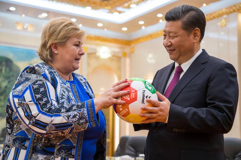 Bildet viser statsminister Erna Solberg som gir en fotball til president Xi Jinping i Kina.