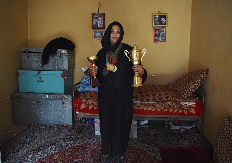 Bildet viser Rasheda Parhiz som viser fram trofeer og medaljer i vektløfting. 