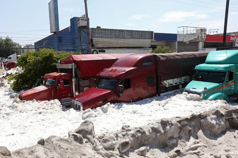 Bildet viser to trailere som er begravd under lag av snø og is.