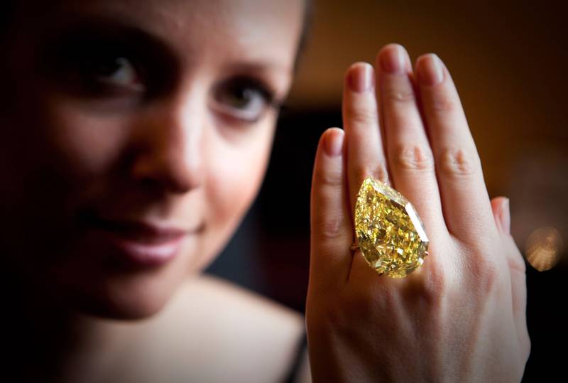 Bilder viser ei dame som har på seg en stor, gul diamant på fingeren.