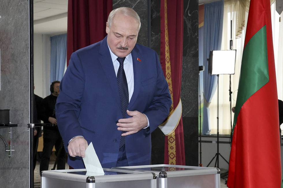 Bildet er av hviterusslands president Aleksandr Lukasjenko. Han putter stemmen sin i en stemmeurne. Foto: BelTA pool via AP / NTB