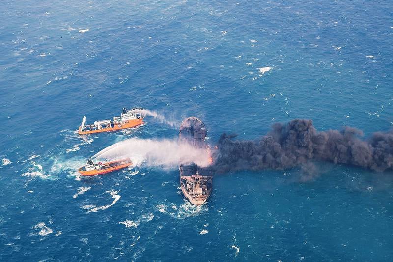 Bildet viser båter som forsøker å slukke brannen om bord på tankskipet.