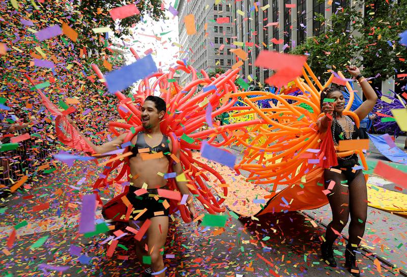 Bildet viser to menn med ballonger og konfetti i masse farger. 