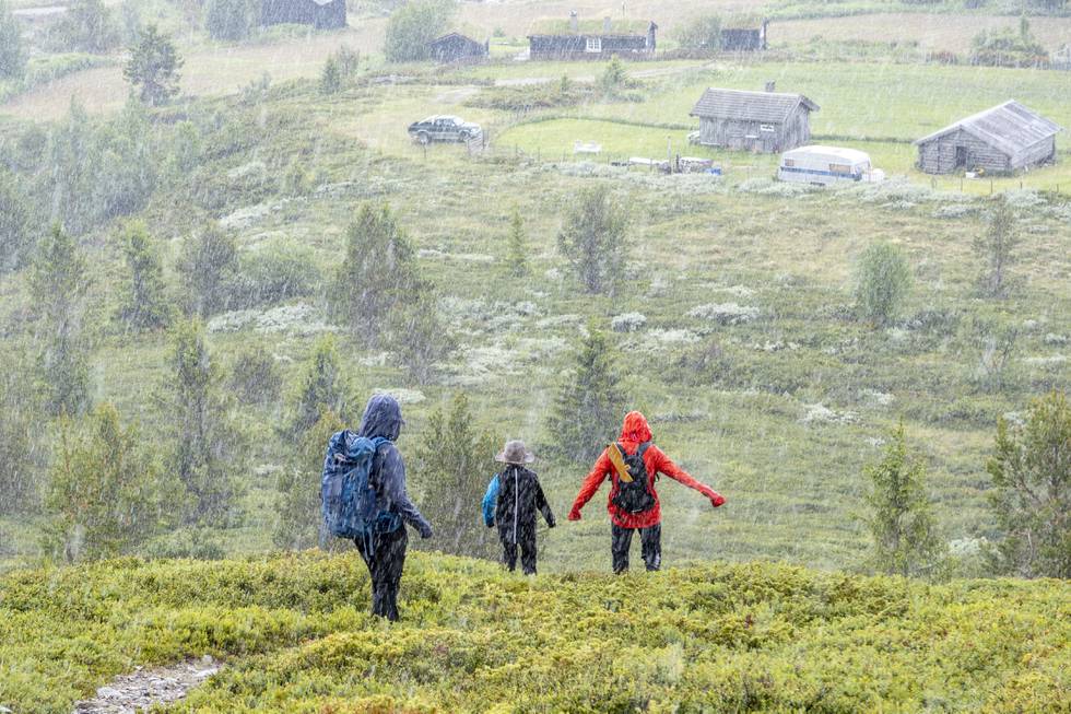 Bildet viser fotturister i regnvær i Gravdalen på fjellet mellom Kvam og Vinstra i Gudbrandsdalen.NVE har oppjustert farevarselet til gult nivå.