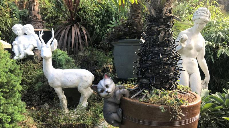 Bildet viser statuer i hagen. De er av barn, en kvinne, en katt og et rådyr.