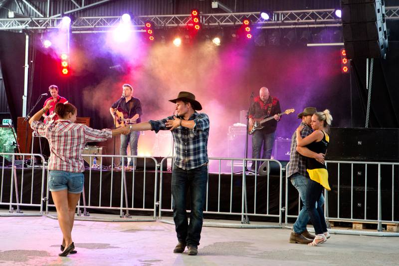 Bildet viser et par som danser foran musikerne på scenen på Countryfestivalen på Vinstra.