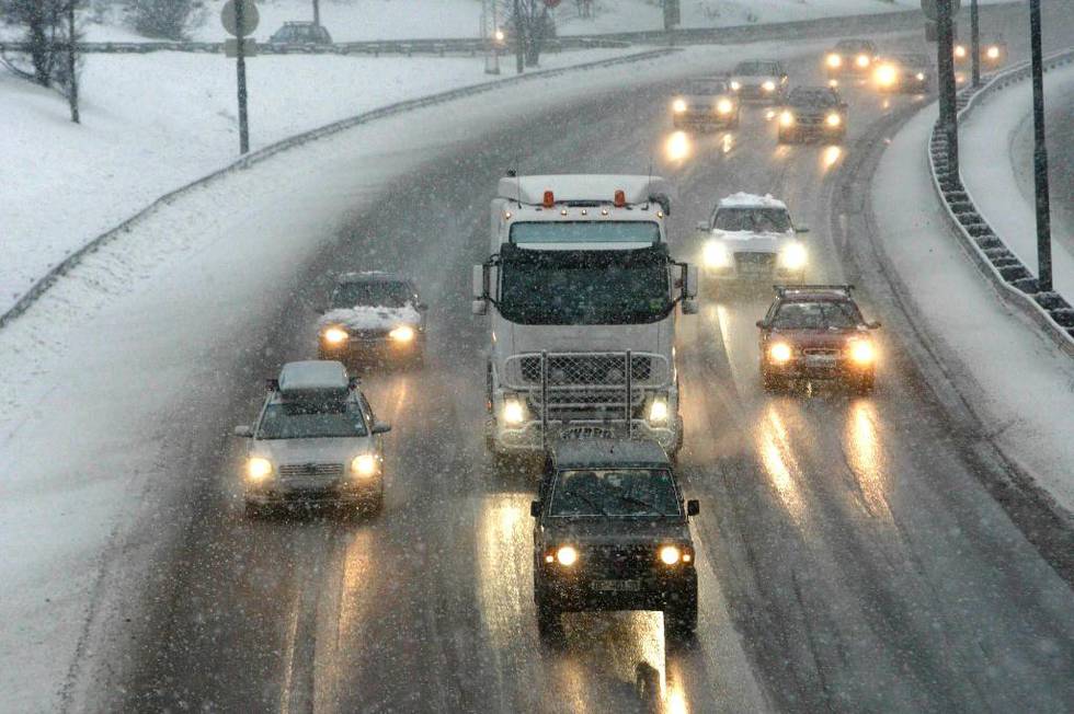 Bildet viser biler på en motorvei i snøvær. 