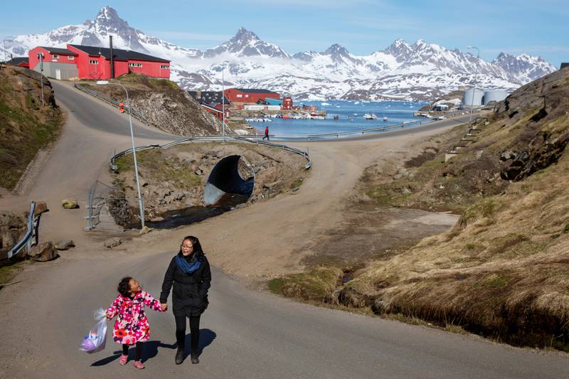 Bildet viser en mor og datter som går i byen Tasiilaq på Grønland.