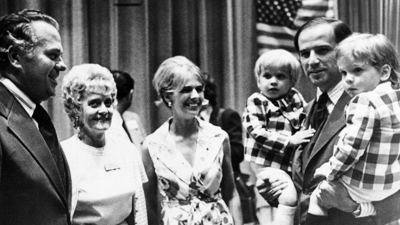 Bildet viser Joe Biden på et sort-hvitt bilde. Han holder to sønner. Kona Neilia står ved siden hans.