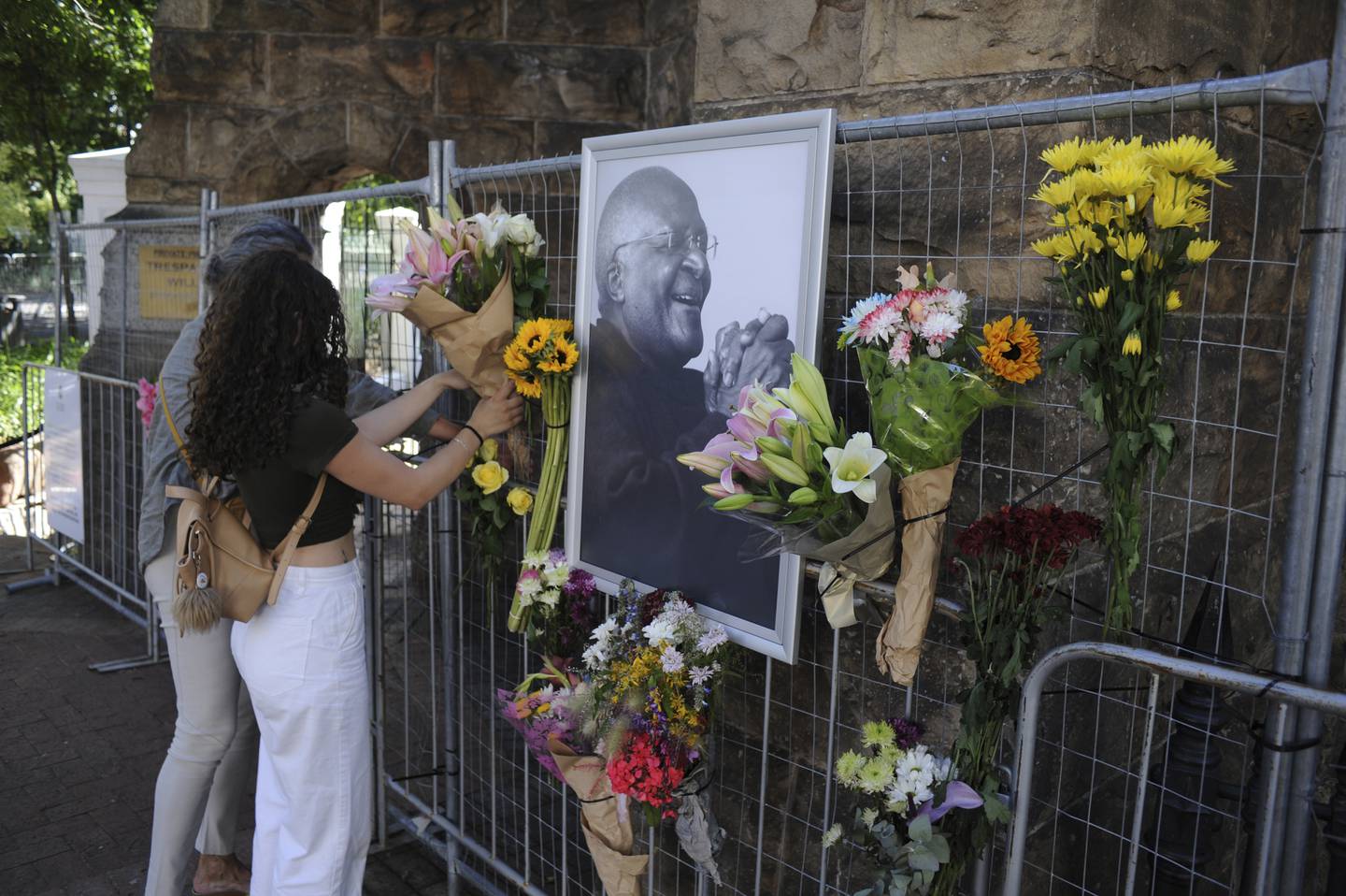 Folk i Sør-Afrika minnes Desmond Tutu utenfor St. George-katedralen i Cape Town søndag. Foto: AP / NTB
