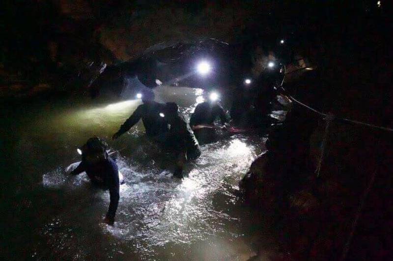 Bildet viser redningsarbeidere inne i en grotta i Thailand. 12 gutter og en fotballtrener har sittet fanget i en grotte i over to uker. Søndag ble fire av guttene reddet ut.