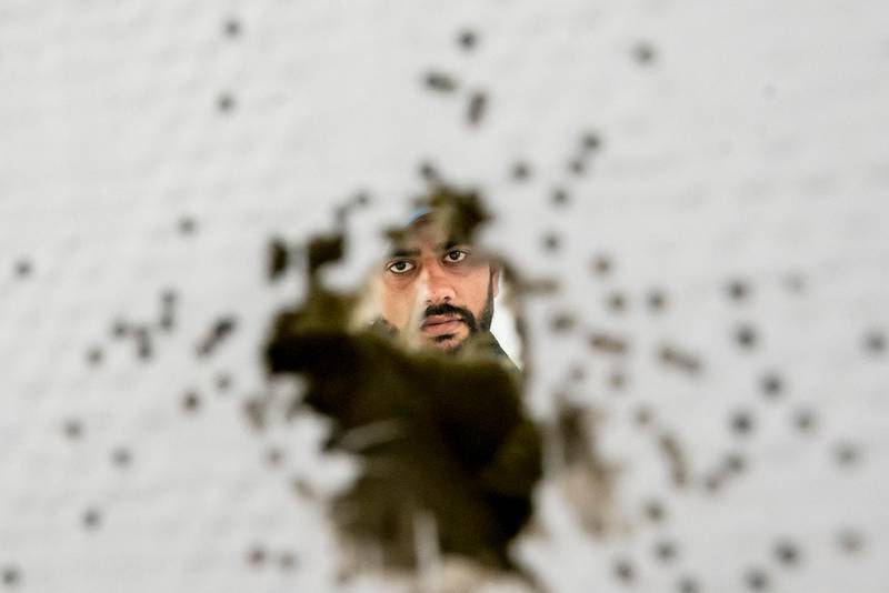 Bildet viser ansiktet til Hafeez Ahmed gjennom et kulehull.