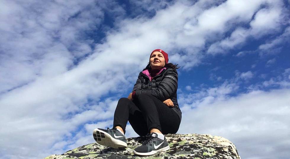 Bildet viser Fareshta Shaheed på en stein foran en blå en skyhimmel.
