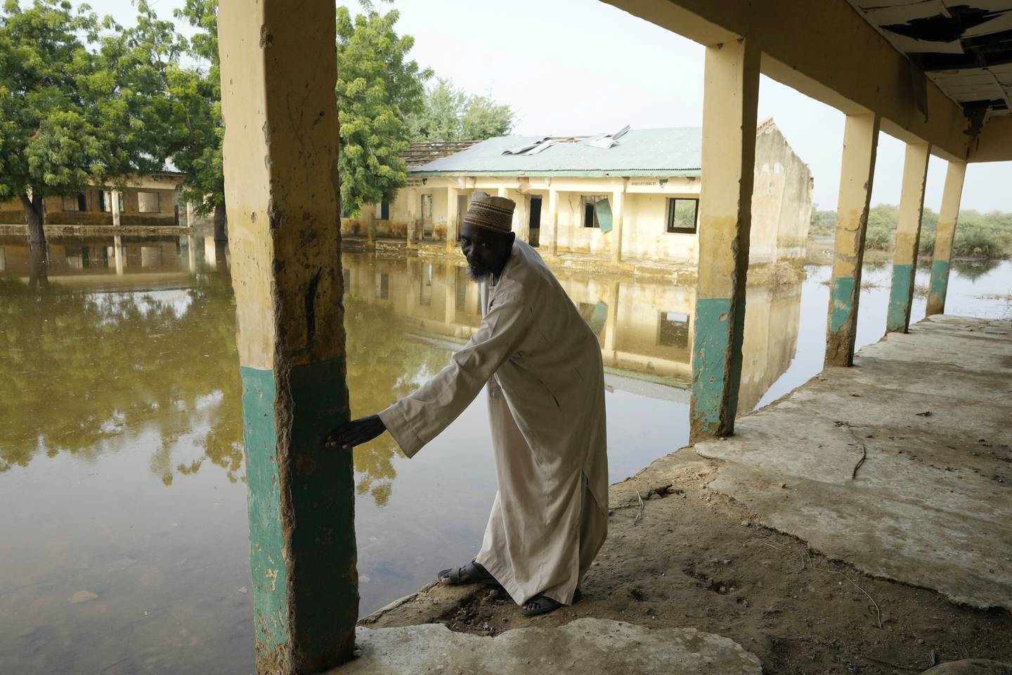 Lærer Musa Saleh viser hvor høyt vannet sto under flommen i Nigeria tidligere i år. Over 1,3 millioner mennesker ble drevet på flukt i Nigeria som følge av flommen og over 600 mennesker mistet livet. Foto: Sunday Alamba / AP / NTB