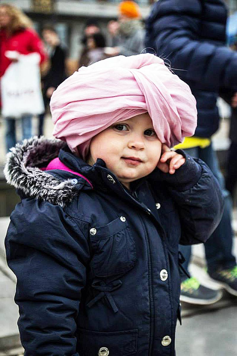 Bildet viser en liten jente som har rosa turban på seg.