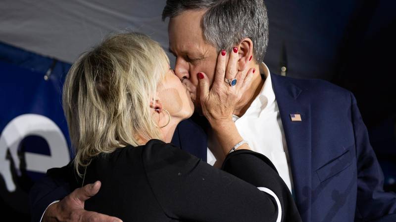 Bildet viser senator Steve Daines som kysser kona.